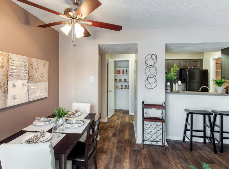 Dining room with ceiling fan, view of kitchen with breakfast bar, and hardwood style floors